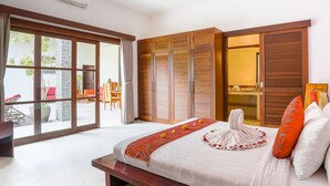 A bedroom with a large bed, a bench, and a view of the outside.