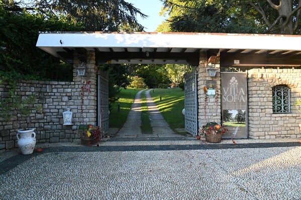 A stone entrance with a pergola, a sign reading 'VILLA SOFIA,' and a pathway leading into a green area. - Wonderful Villa Between Como And Milano (Sirtori)