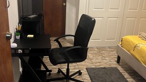 A bedroom with a bed, a desk with a computer, a chair, and a door. - Room-bahamas Petapat Suite (Nassau)