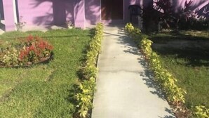 A single-story house with a front door, a small porch, and a pathway leading to the entrance. - Room-bahamas Petapat Suite (Nassau)