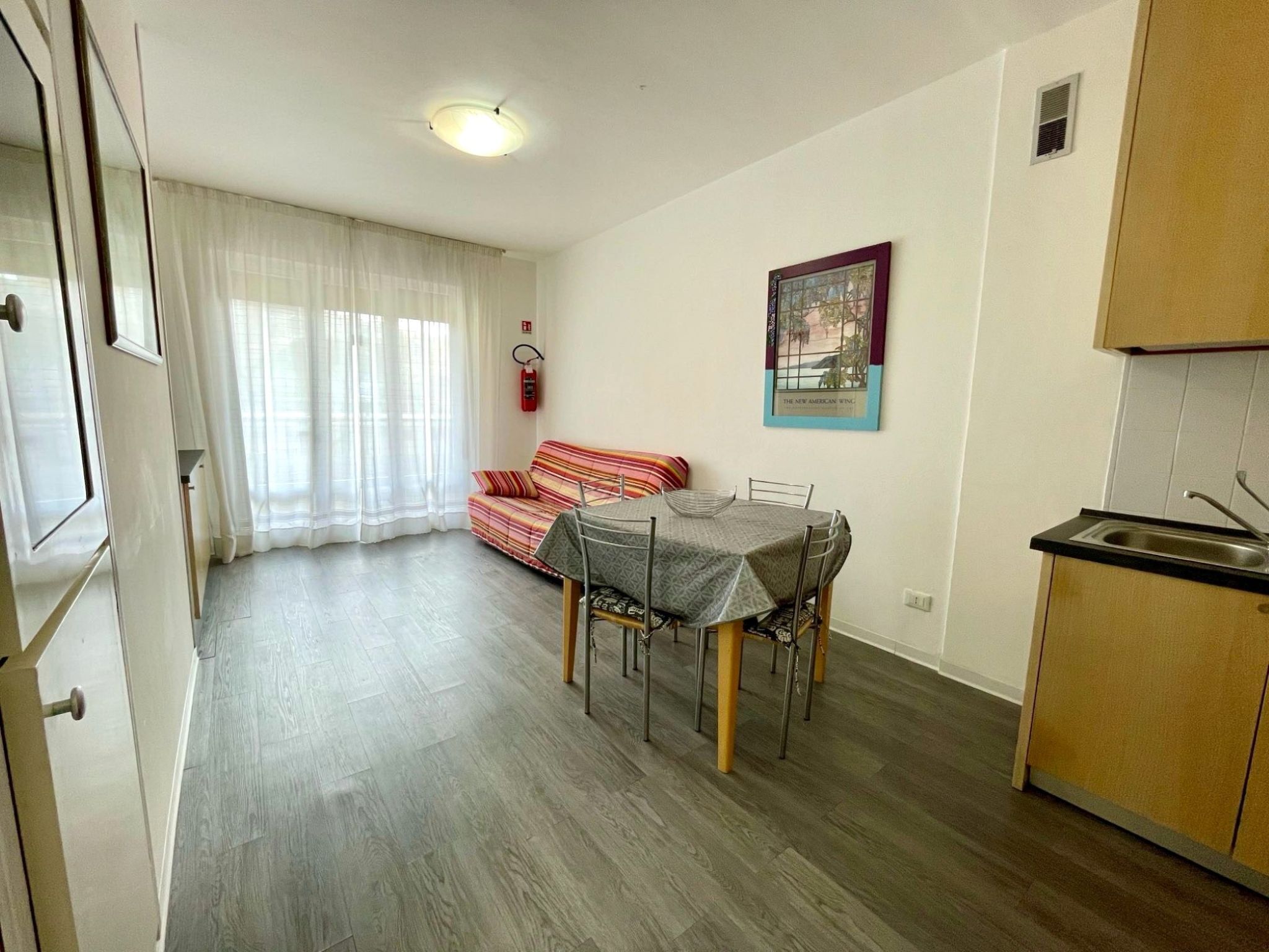 Um espaço compacto com área de refeições, cozinha compacta e sofá.