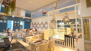 A modern interior with a glass counter, seating area, and decorative elements like hanging plants and framed pictures. - My Resort Hua Hin Water Park Bunk Bed Family Pool View (Hua Hin)