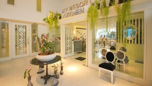 A hotel lobby with a 'My Resort Kitchen' sign, potted plants, and a seating area with chairs and a table. - My Resort Hua Hin Water Park Bunk Bed Family Pool View (Hua Hin)