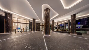 A modern hotel lobby with a central column, glass entrance, and a sign reading "DORSETT". - The Star Residences Gold Coast (Broadbeach)