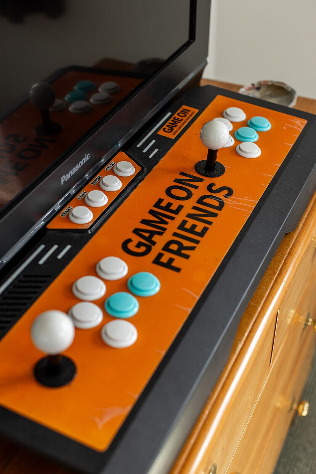 A game console with a "GAME ON FRIENDS" label and various buttons.