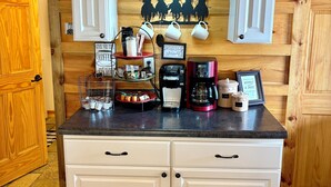 Una cucina con mobili bianchi, un angolo caffè e rivestimenti in legno.