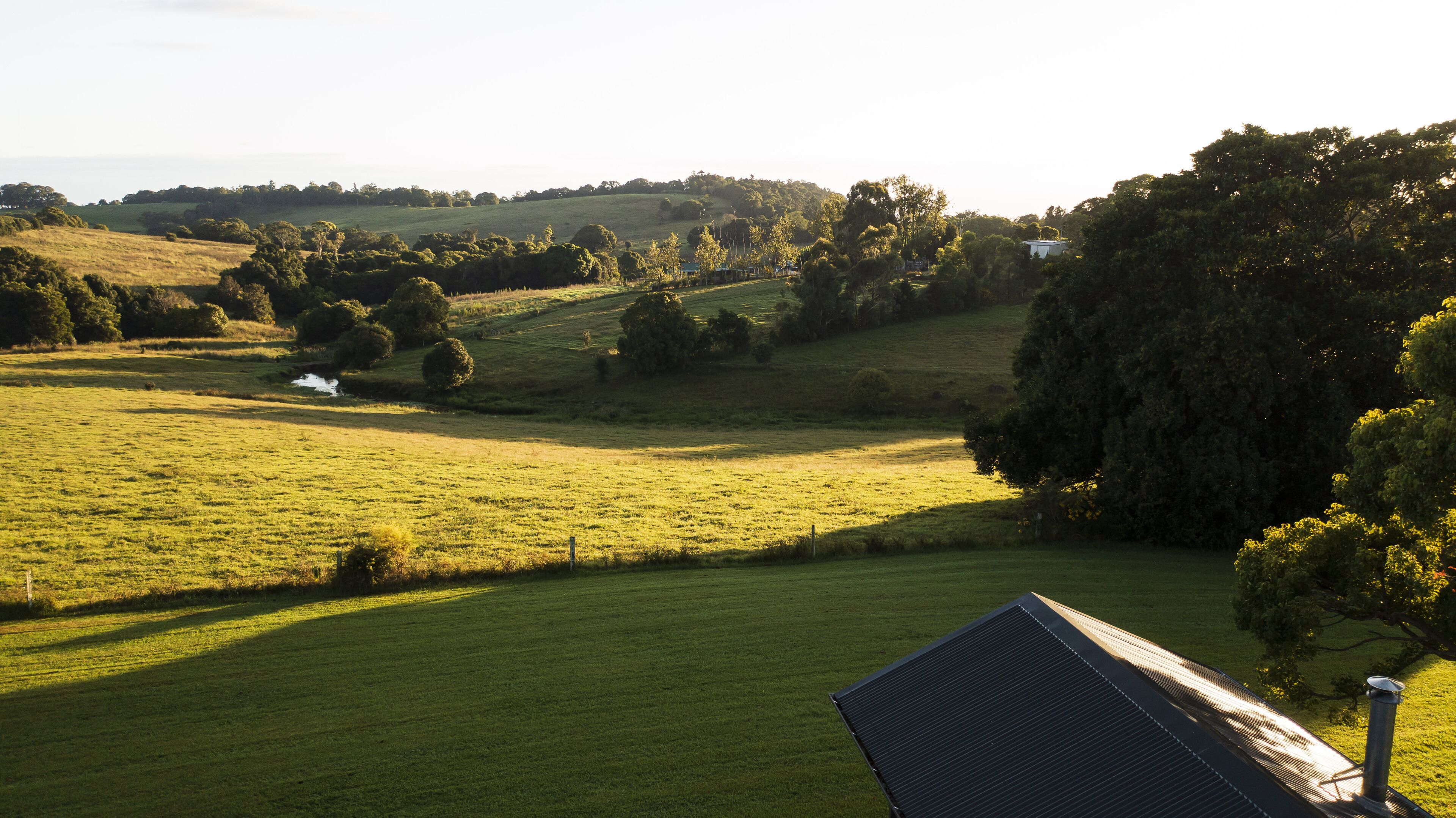 A rural landscape with a house and a solar panel.