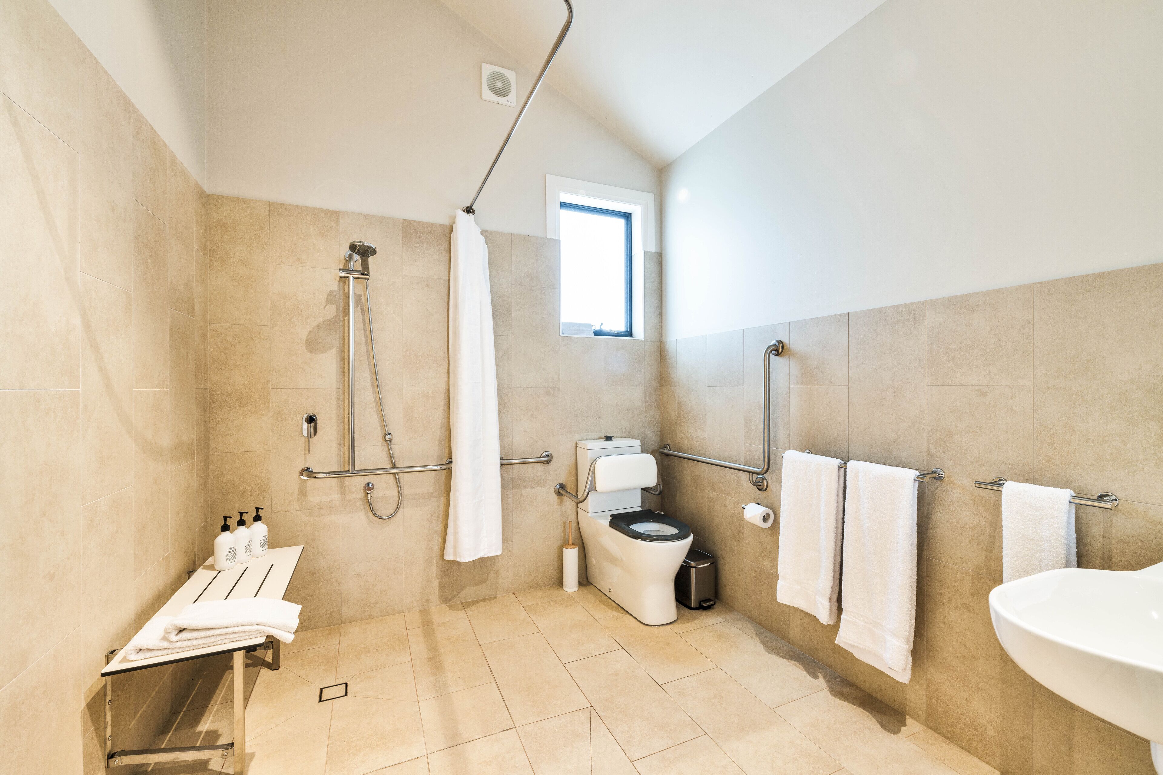 Un baño moderno con ducha, inodoro y lavamanos.