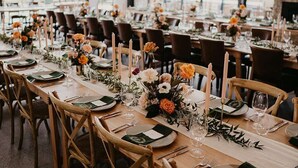 A long dining table set with chairs, candles, and floral centerpieces in a room with large windows and a fireplace. - Beechmont Estate (Beechmont)