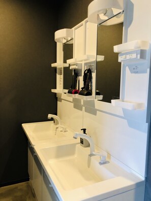 A modern bathroom with two sinks, a large mirror, and a towel rack. - SAMURISE 81INN (Fujikawaguchiko)