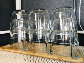 A set of clear glass tumblers stacked on a wooden tray. - SAMURISE 81INN (Fujikawaguchiko)