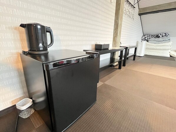 Uma cozinha moderna com bancada preta, chaleira e máquina de café.