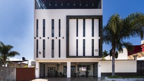 Un edificio moderno de dos pisos con techo plano, ventanas grandes y un área de entrada cubierta.
