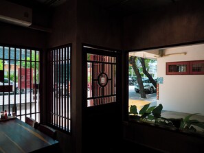 A room with a view of the street through a window with a metal gate. - Niagara Hotel (Bang Rak)