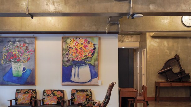 A lobby with a seating area, two paintings of flowers, and a clock on the wall. - Niagara Hotel (Bangkok)