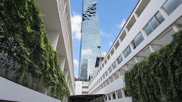 Un bâtiment moderne avec une façade en verre et une structure blanche en premier plan.