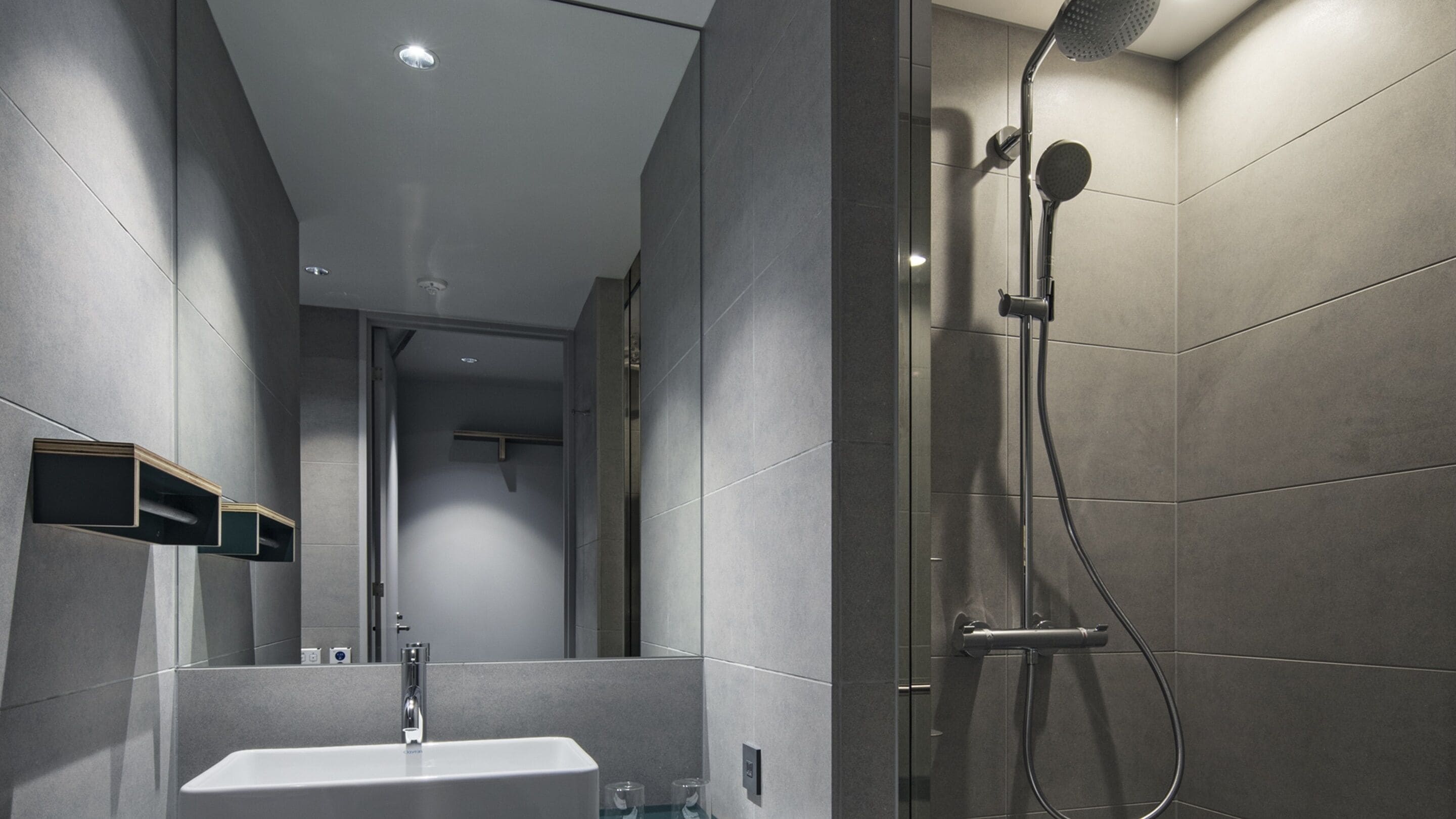Ein modernes Badezimmer mit Dusche, Waschbecken und Spiegel.