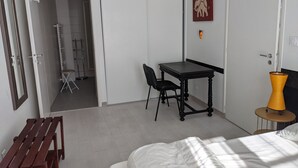 A bedroom with a bed, a desk with a chair, a small table with a lamp, and a door. - For family fun at the beach, at the center of everything that matters (Les Sables-d'Olonne)