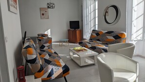 A living room with a sofa, two armchairs, a coffee table, a television, and a small cabinet. - For family fun at the beach, at the center of everything that matters (Les Sables-d'Olonne)