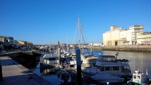 A marina with boats docked, a bridge, and buildings in the background. - For family fun at the beach, at the center of everything that matters (Les Sables-d'Olonne)