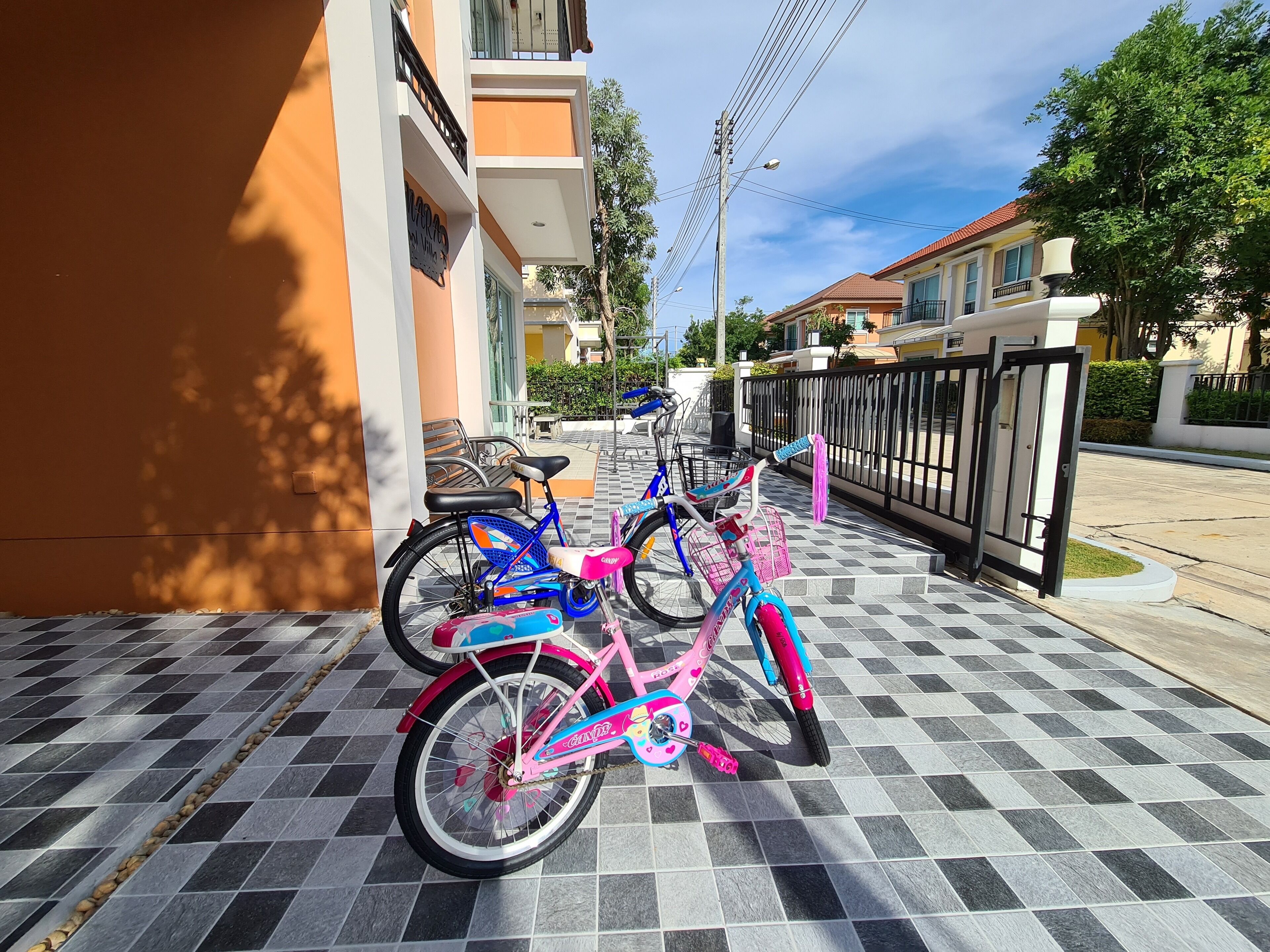 Un vélo est garé sur un trottoir carrelé, à côté d’un immeuble.