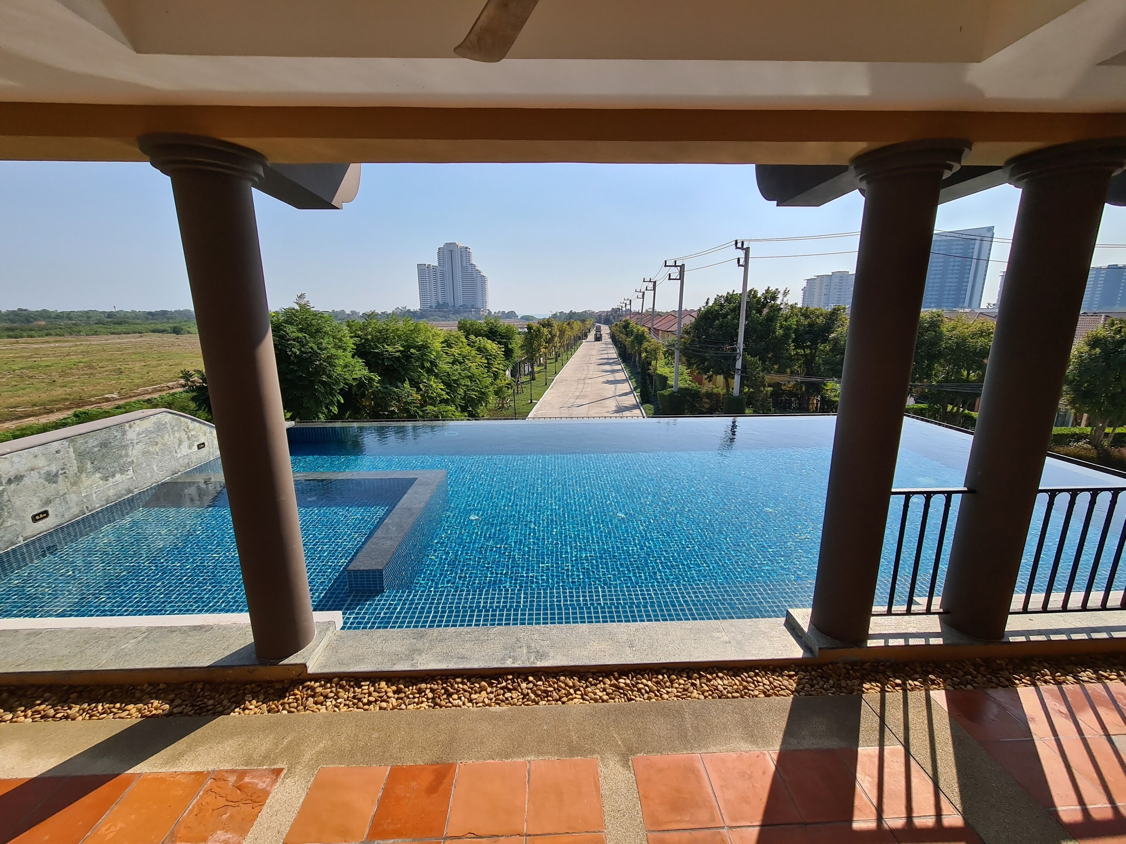 An infinity pool with a clear view of a distant road and buildings.