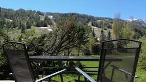 Ein Tisch und zwei Stühle mit Blick auf die Berge.
