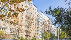 A multi-story residential building with balconies, parked cars, and trees. - Studio 54 by MRG Apartments (Bucharest)