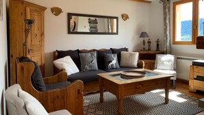 A cozy living room with a wooden sofa, a coffee table, and a bookshelf. - Spacious chalet in Pra Loup, 4 bedrooms, WiFi (Pra-Loup)