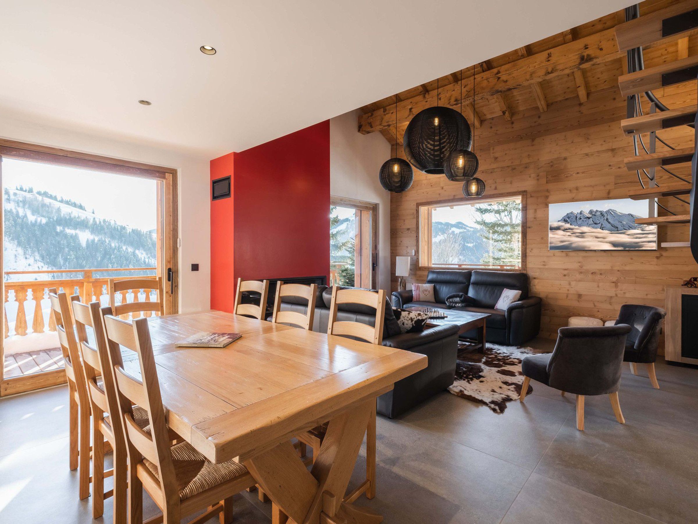 A modern interior with a wooden dining table, chairs, a sofa, and a fireplace.