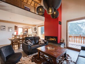 A spacious living area with a fireplace, a dining table, and a sofa.