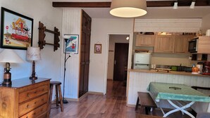 Una cocina acogedora con armarios de madera, un microondas y una mesa con mantel verde.