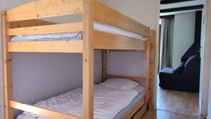 Un lit superposé à deux niveaux, avec une structure en bois et un matelas sur chaque niveau.