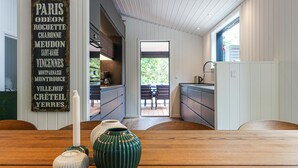 Una cucina moderna con vista su un patio, arredamento in legno e un cartello rustico con nomi francesi.