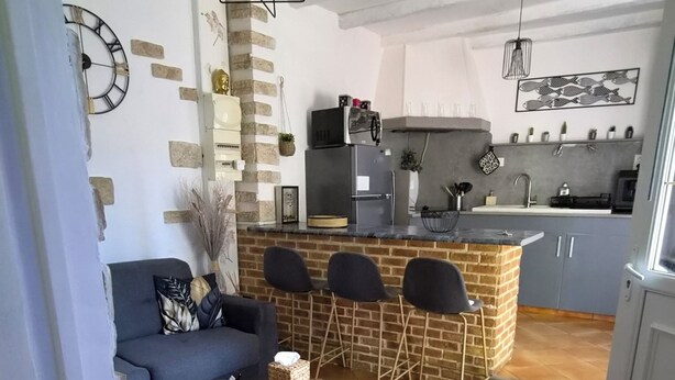 Een moderne woonkamer met een bank, een salontafel en een eethoek met stoelen.