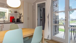 Une cuisine moderne avec un coin repas, une grande fenêtre et une vue sur l’extérieur.