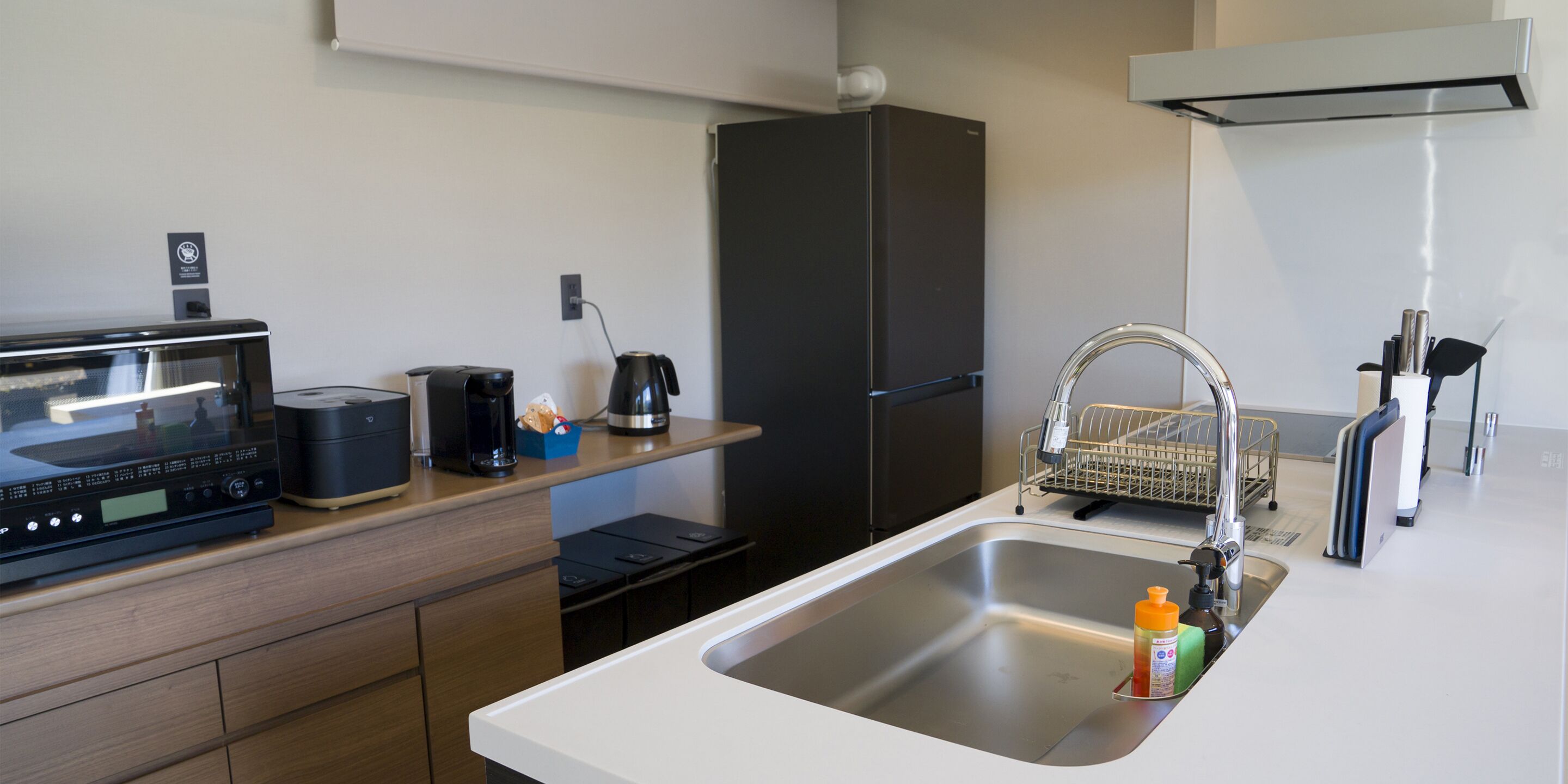 A modern kitchen with a microwave, coffee maker, and refrigerator.
