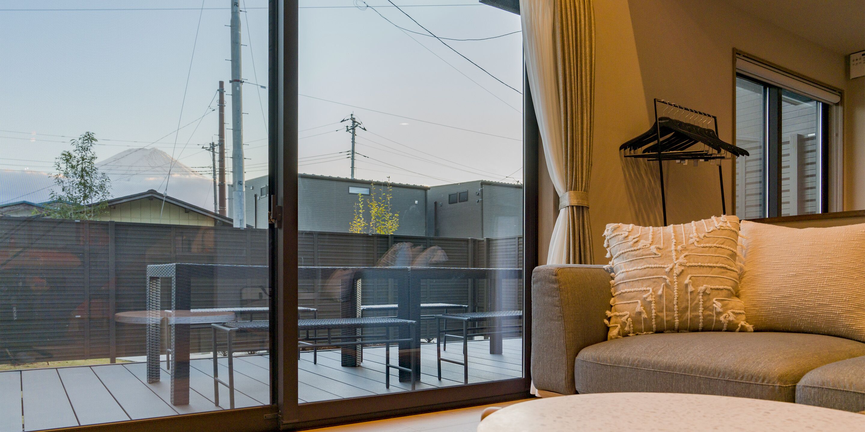 A living room with a sofa, a coffee table, and a view of a patio area with outdoor furniture.