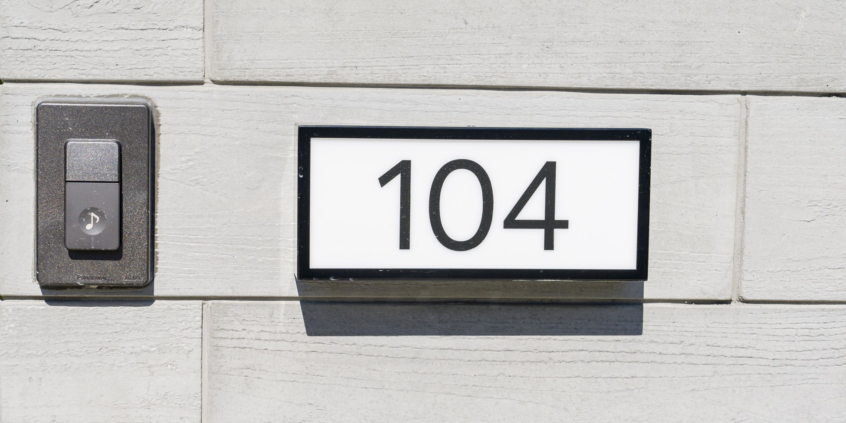 A house number sign with the number 104.