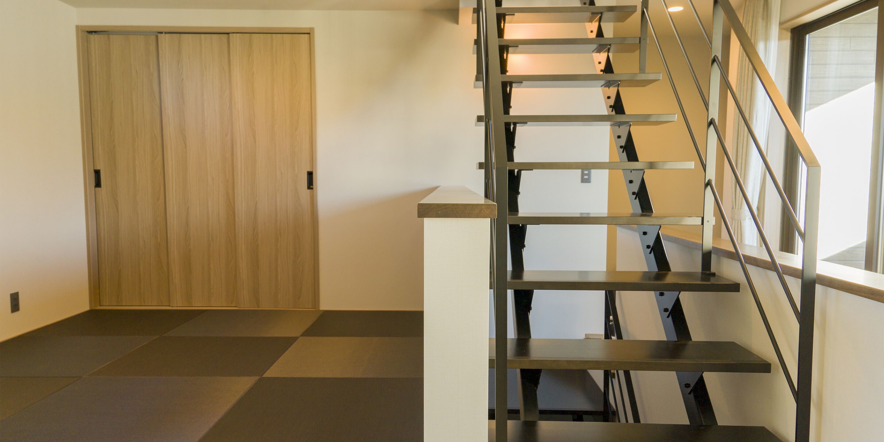 Een modern interieur met een houten deur en een metalen trap.