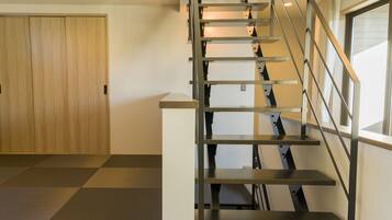Een modern interieur met een houten deur en een metalen trap.