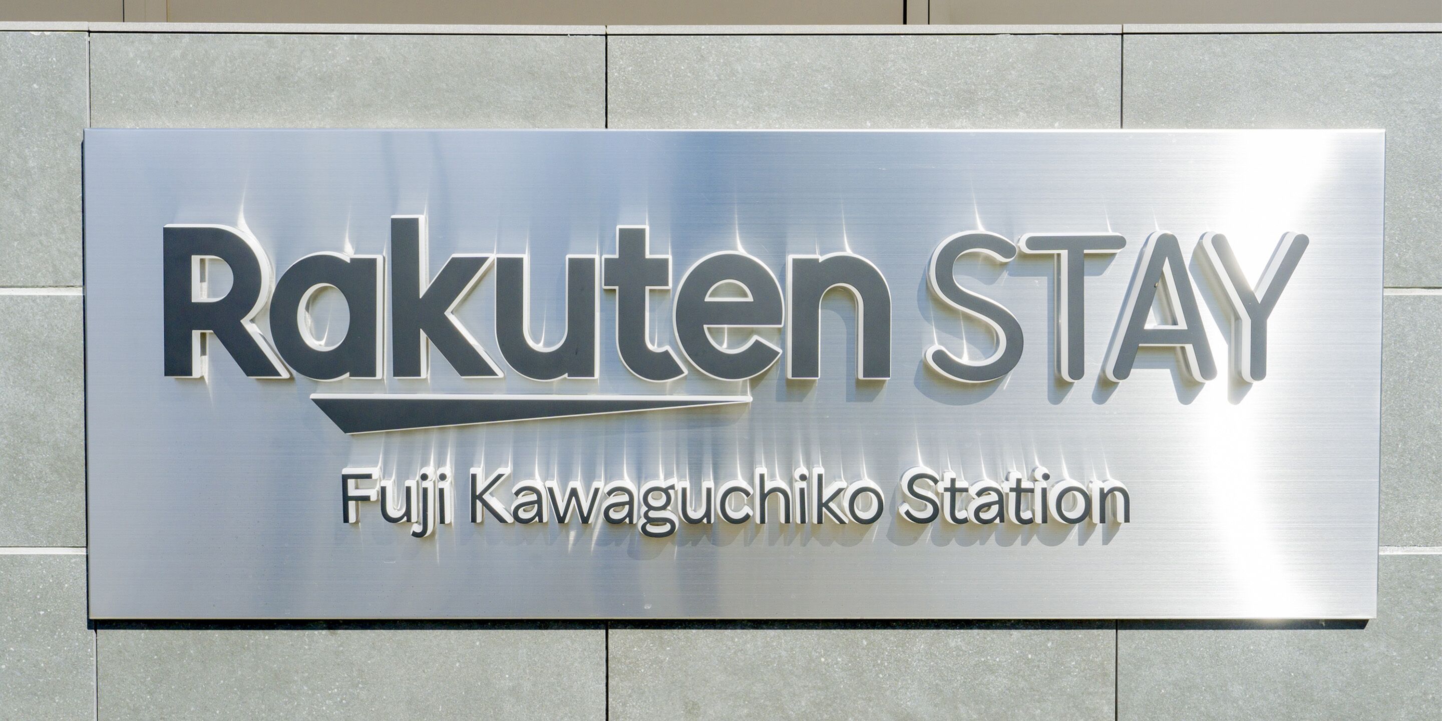 A sign for Rakuten STAY at Fuji Kawaguchiko Station.
