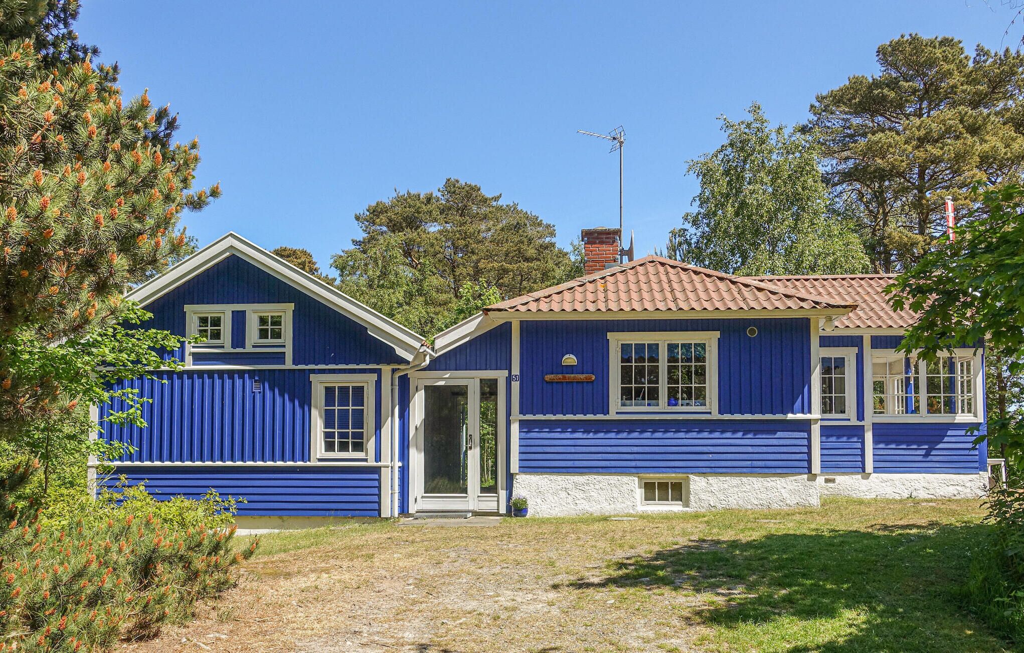 A two-story house with a blue exterior and a red-tiled roof.