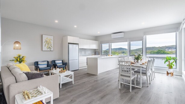 A modern apartment with a kitchen, dining area, and living room. - Fingal Bay Seabreeze Unit 2  16 Tuna Crescent (Fingal Bay)