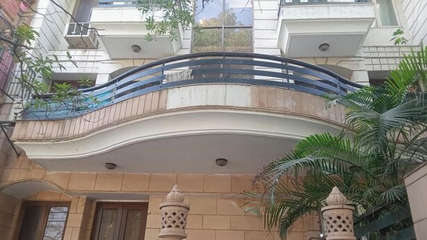 A multi-story building with a curved balcony, large windows, and a central entrance. - 2 Bed Apartment Sleeps 4 With Parking New Delhi (New Delhi)