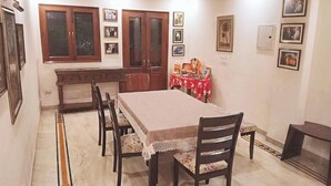 A dining area with a rectangular table, six chairs, a ceiling fan, and framed pictures on the walls. - 2 Bed Apartment Sleeps 4 With Parking New Delhi (New Delhi)