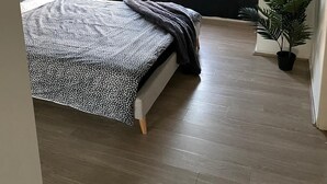 A bedroom with a bed, two windows, a potted plant, and a textured wall. - Spacious 3 bedroom townhouse with AC and lock up garage (Liverpool)