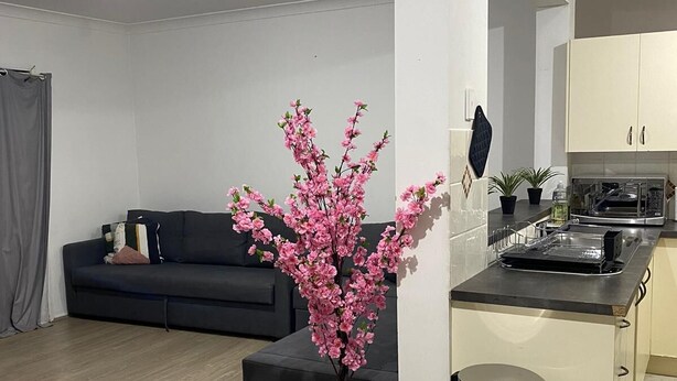 A modern kitchen with white cabinets, a black countertop, and a stainless steel sink. - Spacious 3 bedroom townhouse with AC and lock up garage (Liverpool)