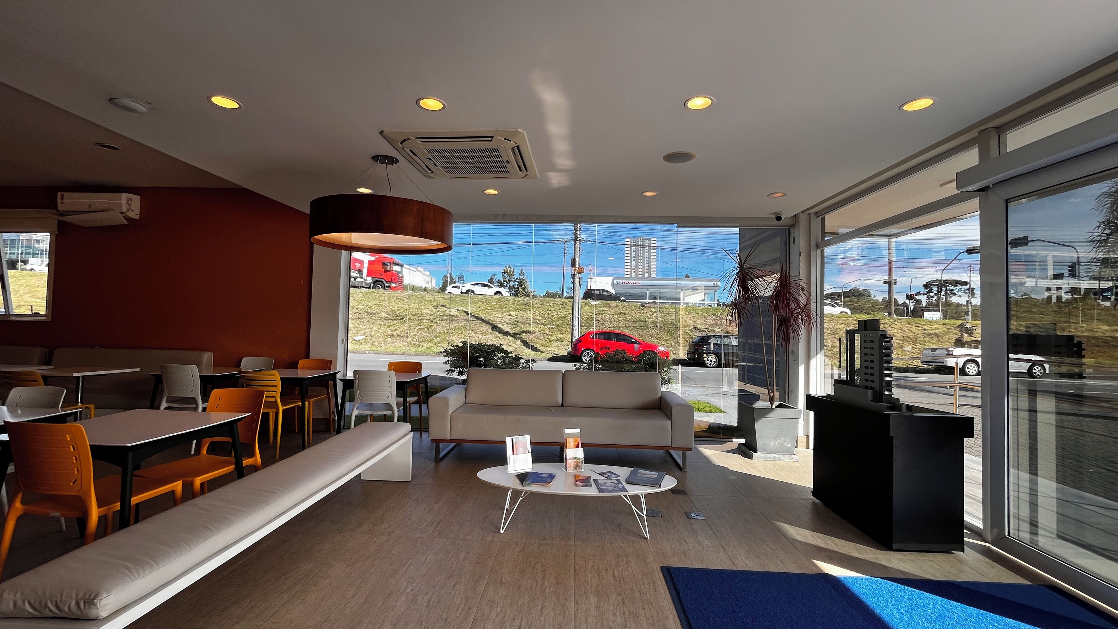 Un intérieur moderne avec un canapé, un coin repas et une vue sur l’extérieur.
