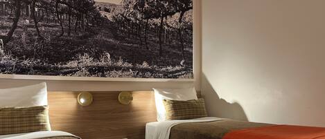 A hotel room with two beds, a nightstand, and a wall-mounted artwork.